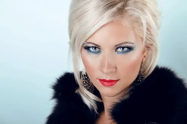 Fashion blond woman with blue eyes and red lips, wearing in fur