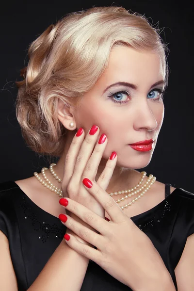 Blond woman with make up and red manicured nails over black, stu