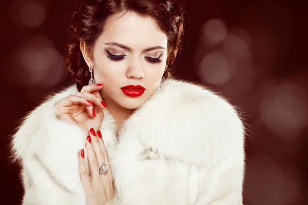 Fashion woman with red lips and nails in fur coat. Luxury and J
