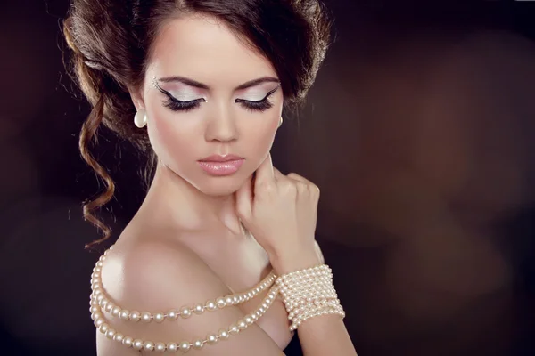 Fashion woman with a pearl necklace on the bared shoulders