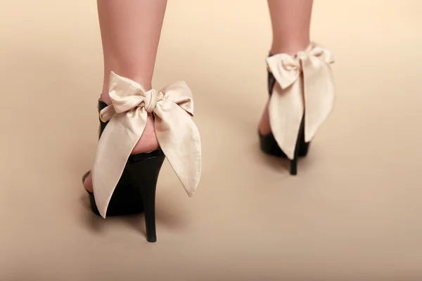 Body part. Fashion shoes over beige background. Studio Photo