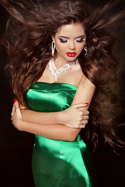 Beautiful fashion girl with long curly hairs in elegant dress po