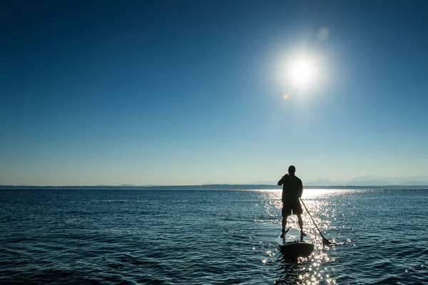 Man paddling stand up paddle board