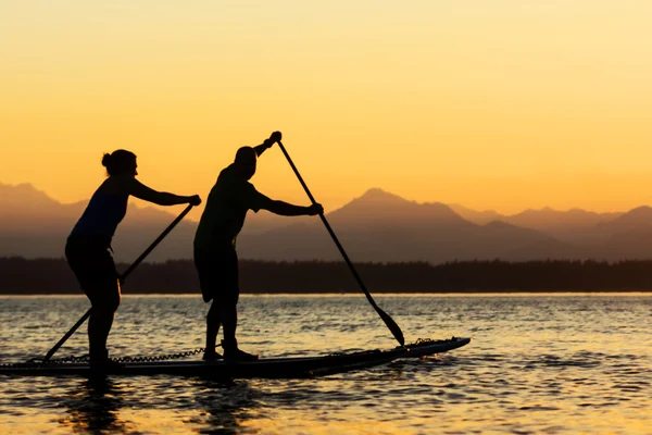 Couple paddling stand up paddle boards