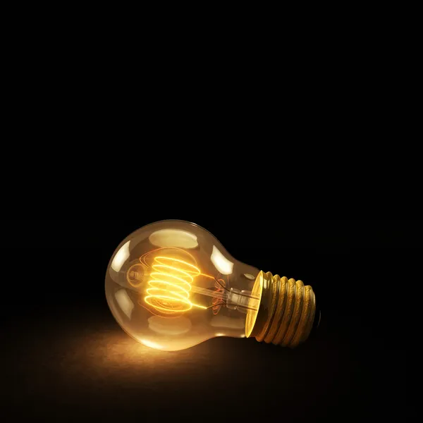 Glowing Incandescent Light Bulb on a Dark Background