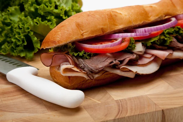 A sub sandwich on a wooden cutting board