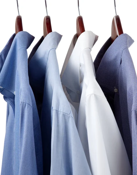 Blue dress shirts on wooden hangers