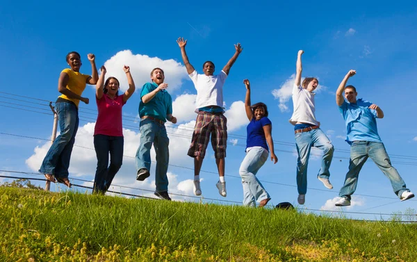 A group of diverse college students, friends jumping in the air