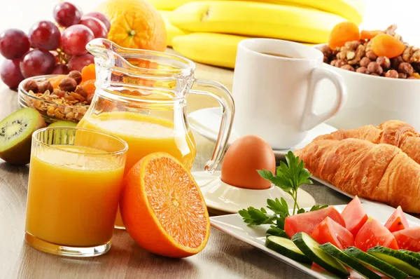 Breakfast with coffee, orange juice, croissant, egg, vegetables