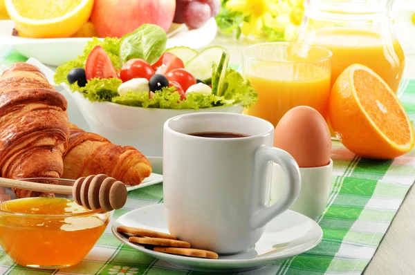 Breakfast with coffee, orange juice, croissant, egg, vegetables