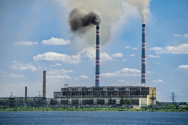 Factory next to river. Air pollution. Industrial landscape.