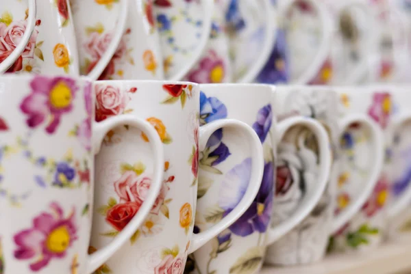 Many white coffee or tea mugs in a line for sale