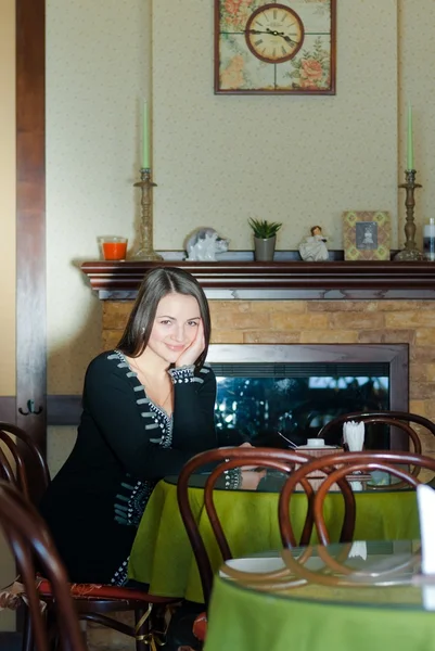 Woman sitting alone in cafe with cup of tea or coffee