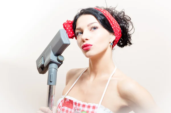 Beautiful funny young black haired blue eyes pinup woman with vacuum cleaner