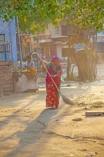 Indian women of fourt class in brightly colored clothing cleans