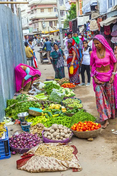 Vendors sell goods in a vegetable street market