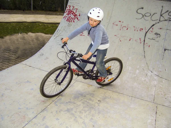 Child with bike in the half pipe