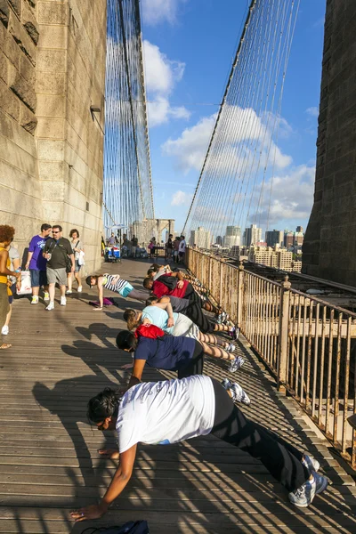 People enjoy exercises at Brooklyn Bridge in New York