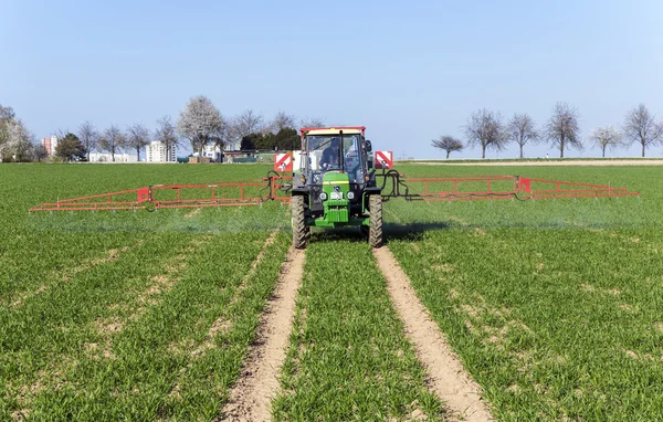 Tractor on field sputtering pest protection