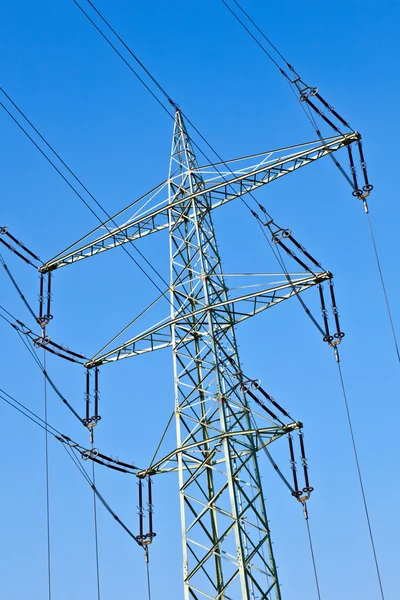 Electricity tower with power lines against a blue sky