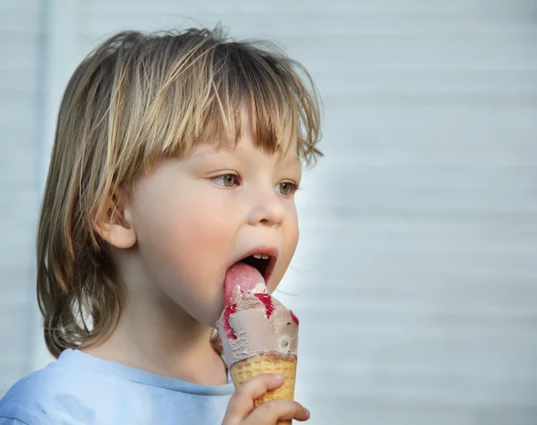 Happy little boy eating an ice cream