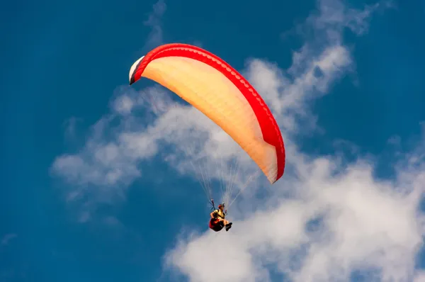 Colorful hang glider in sky over blue sea