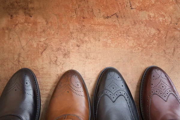 Four men shoe close up on a background of vintage wall