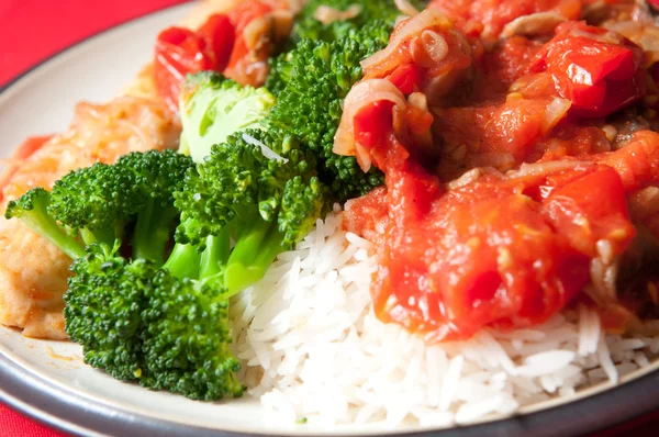 Beautiful poached tilapia fish fillets smothered with healthy tomato and onion sauce, with steamed rice and broccoli
