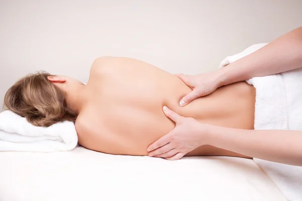 Deep tissue massage on the woman's middle back on erector spinae