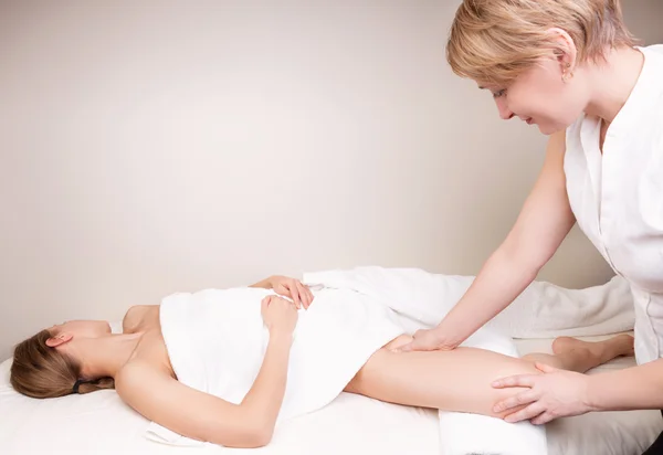 Qualified therapist massaging woman's leg the inner thigh on the