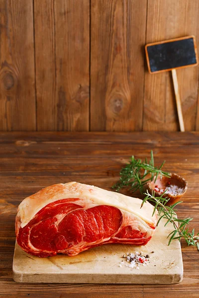 Raw beef Rib bone steak on wooden board and table
