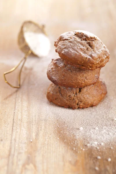Soft ginger cookies three stacked and dusted on wooden table