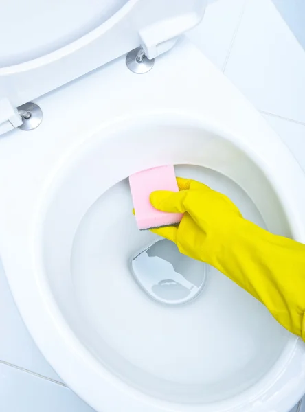 Hands on yellow gloves cleaning a WC