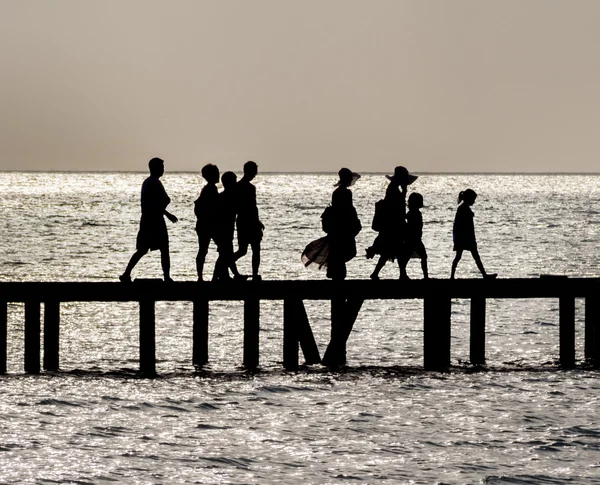 Silhouette of Family crossing bridge