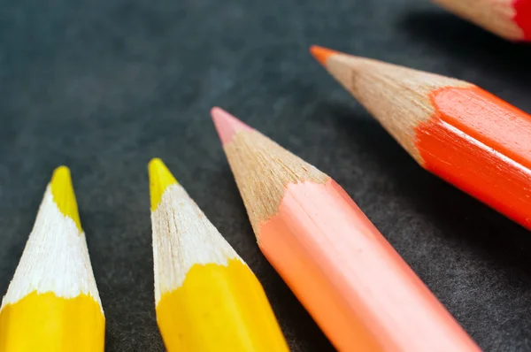 Colorful pencils on dark background lined up