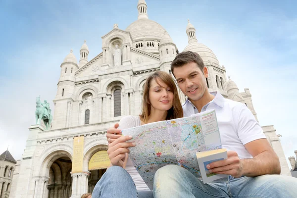 Couple in Montmartre reading tourist map