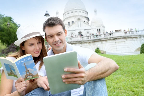 Couple using tablet in front of Sacre Coeur Basilica