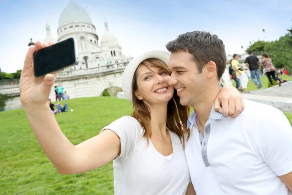 Lovers taking picture of themselves in front of Sacre Coeur