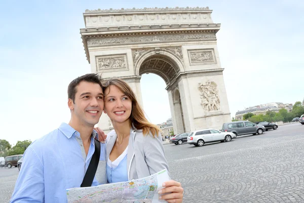 Couple reading map in front of the Arch of Triumph