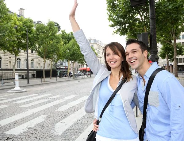 Couple of tourists in Paris calling for a taxi cab