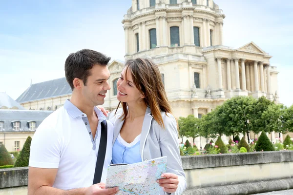 Couple reading tourist map in front of the Invalides building