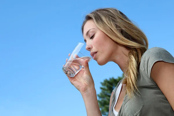 Closeup of blond woman drinking water from glass