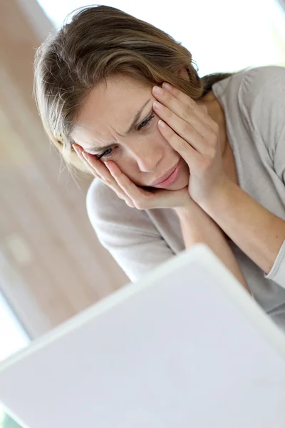 Active woman in front of laptop with upset look