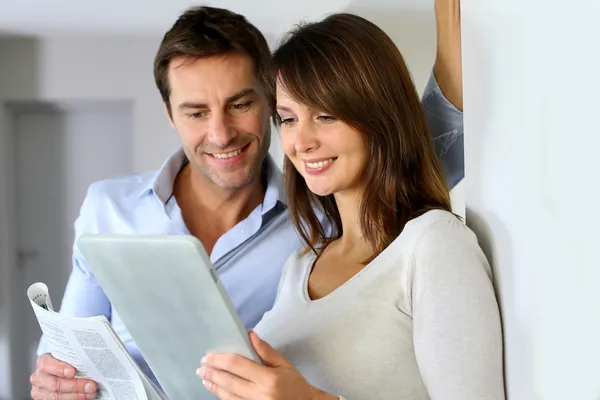 Couple at home reading news on newspaper and internet