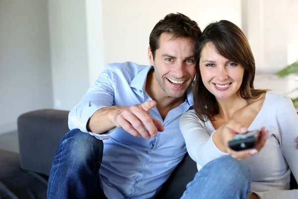 Couple sitting in couch choosing tv program