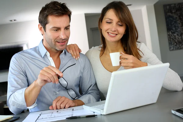 Couple at home looking at future home blueprint