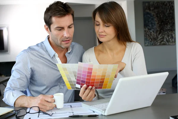 Couple choosing paint colour for their new home