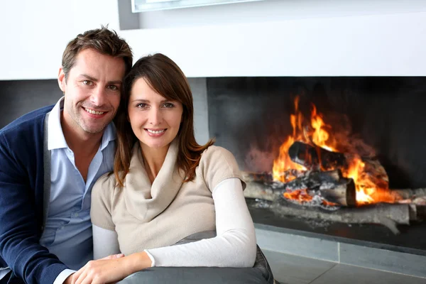 Romantic couple sitting by fireplace at home