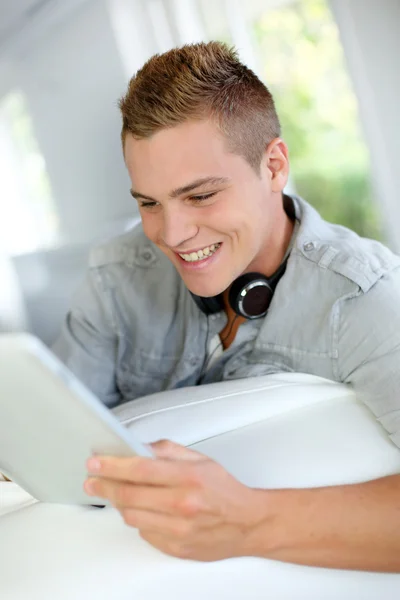 Young man listening to music with digital tablet