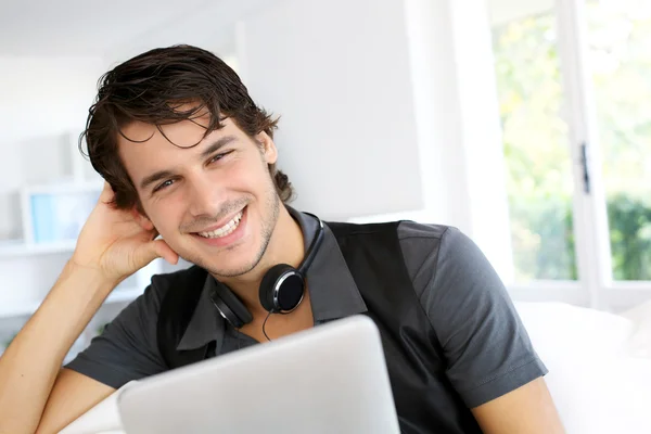 Handsome guy listening to music on internet with tablet